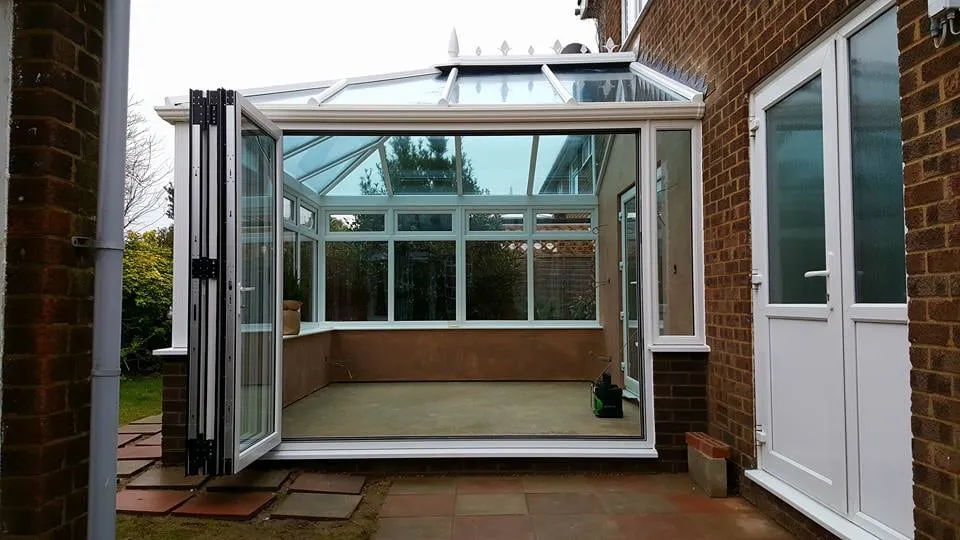 Interior of a completed conservatory with bi-fold doors open onto a patio Everglaze Window Solutions Portsmouth